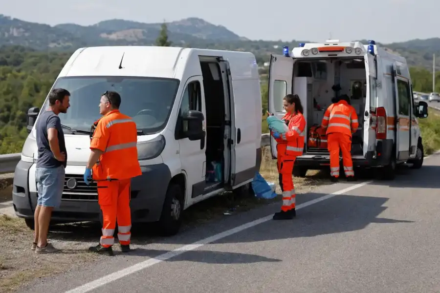 Furgone bianco e ambulanza 118 fermi a bordo strada, con soccorritori in divisa arancione e un uomo che parla con un